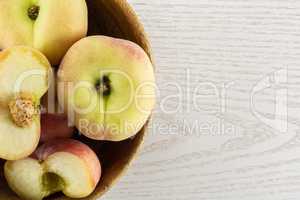 Fresh raw saturn peach on grey wood