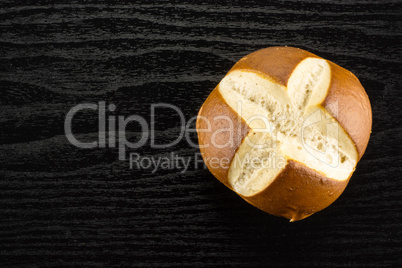 Fresh Bavarian bread bun on black wood