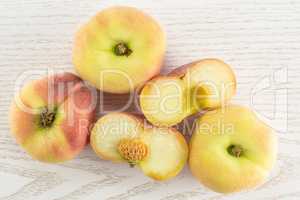 Fresh raw saturn peach on grey wood