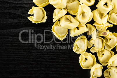 Fresh Raw tortellini pasta on black wood