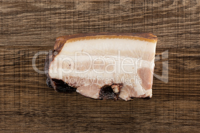 Fresh smoked english bacon on brown wood
