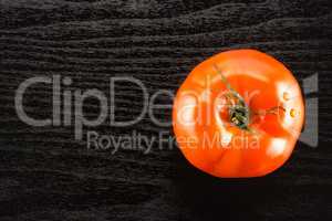 Fresh raw Tomato (La Parcela variety) on black wood