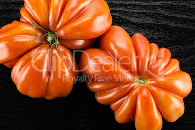 Fresh Raw Beef Tomato on black wood