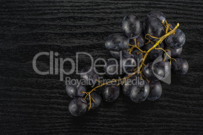 Fresh Black Wine Grapes on Black wood