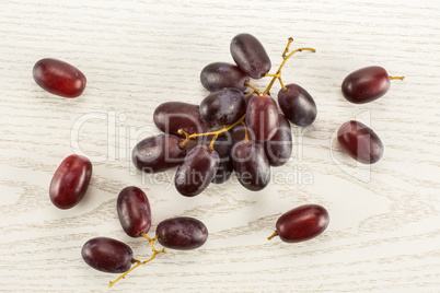 Raw fresh red globe grape on grey wood