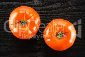 Fresh raw Tomato (La Parcela variety) on black wood