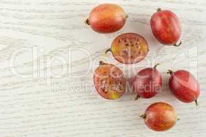Fresh raw red gooseberry on grey wood