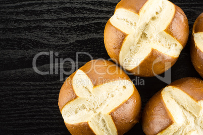 Fresh Bavarian bread bun on black wood