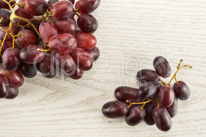 Raw fresh red globe grape on grey wood