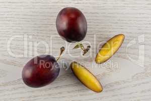 Fresh Raw vibrant plums on grey wood