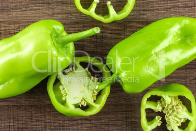 Fresh raw light green pepper on brown wood