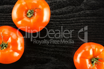 Fresh raw Tomato (La Parcela variety) on black wood