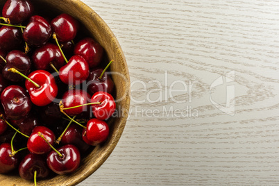 Fresh raw sweet red cherry on grey wood