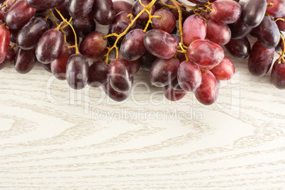 Raw fresh red globe grape on grey wood