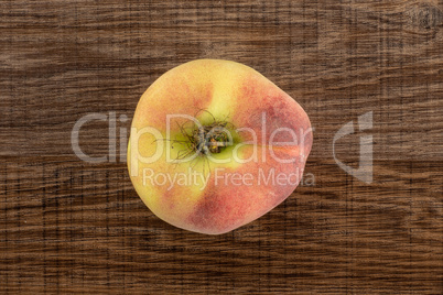 Fresh raw saturn peach on brown wood