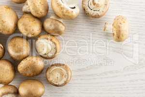 Fresh raw brown champignons on grey wood