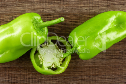 Fresh raw light green pepper on brown wood