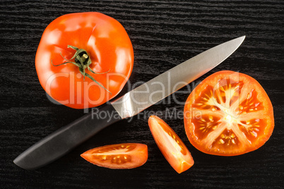 Fresh raw Tomato (La Parcela variety) on black wood