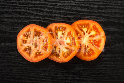 Fresh raw Tomato (La Parcela variety) on black wood