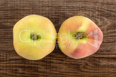 Fresh raw saturn peach on brown wood