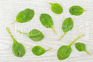 Fresh raw green spinach on grey wood