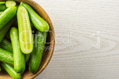 Fresh raw mini cucumber on grey wood