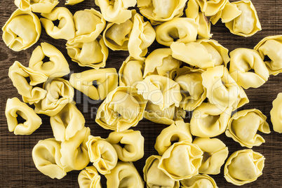 Fresh Raw tortellini pasta on brown wood