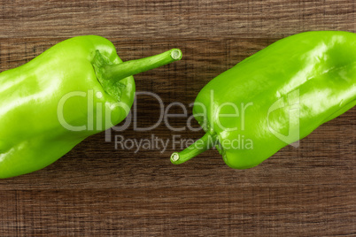 Fresh raw light green pepper on brown wood