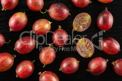 Fresh raw red gooseberry on black wood