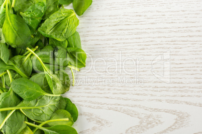 Fresh raw green spinach on grey wood