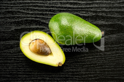 fresh Raw smooth avocado on black wood