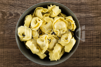 Fresh Raw tortellini pasta on brown wood