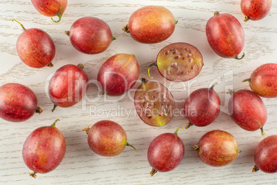 Fresh raw red gooseberry on grey wood