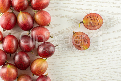 Fresh raw red gooseberry on grey wood