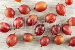 Fresh raw red gooseberry on grey wood