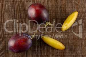 Fresh Raw vibrant plums on brown wood