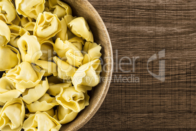 Fresh Raw tortellini pasta on brown wood