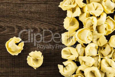 Fresh Raw tortellini pasta on brown wood