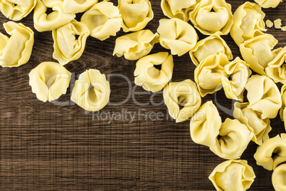 Fresh Raw tortellini pasta on brown wood