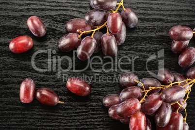 Raw fresh red globe grape on black wood