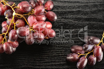 Raw fresh red globe grape on black wood