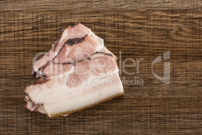 Fresh smoked english bacon on brown wood