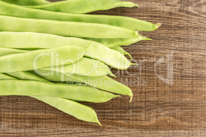 Fresh Flat Green Bean on brown wood