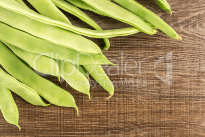 Fresh Flat Green Bean on brown wood