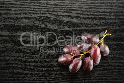 Raw fresh red globe grape on black wood