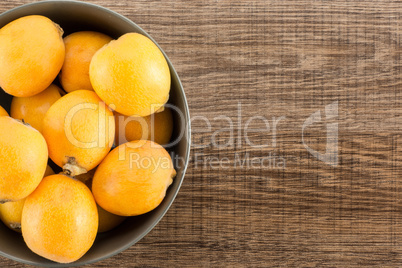 Fresh raw orange japanese loquat on brown wood