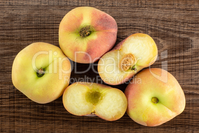 Fresh raw saturn peach on brown wood