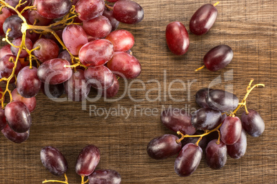 Raw fresh red globe grape on brown wood