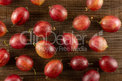 Fresh raw red gooseberry on brown wood