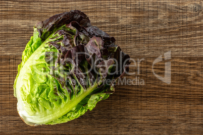 Fresh raw lettuce red little gem on brown wood